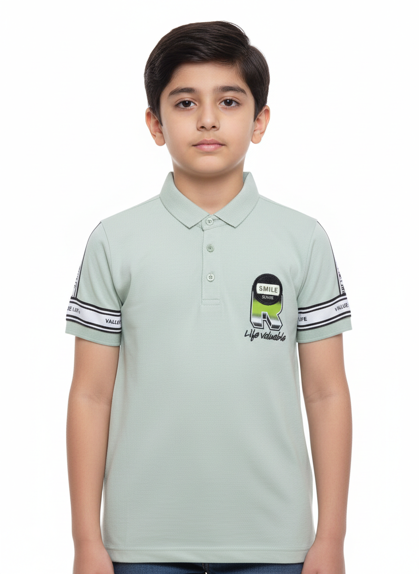 A Contemporary Portrait Featuring A Young Boy In A Soft Sage Green Graphic Polo
