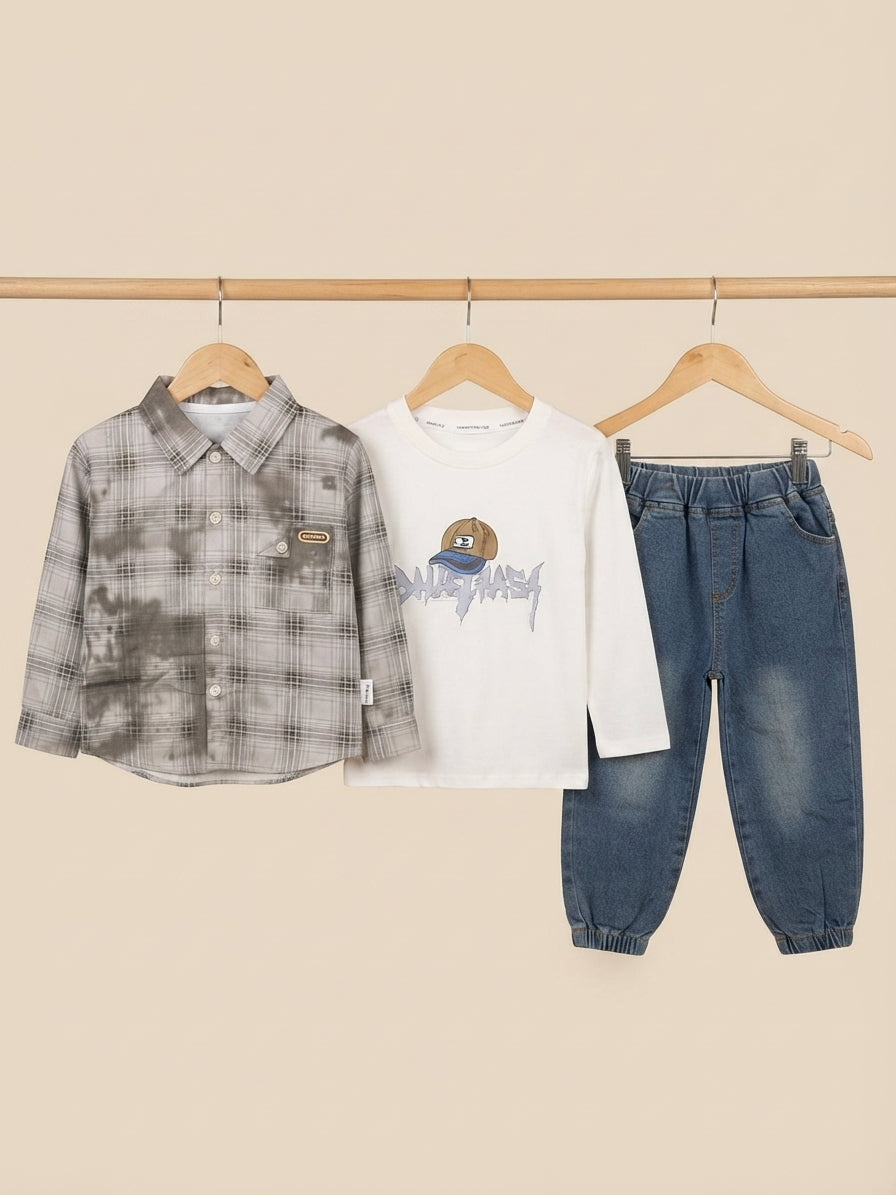 Stylish boys three-piece clothing set featuring a plaid shirt, graphic t-shirt, and denim jeans.